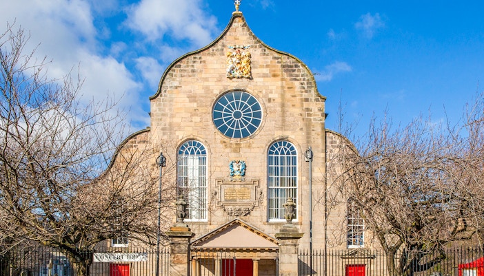 Canongate Kirk in Edinburgh with historic architecture and surrounding greenery.
