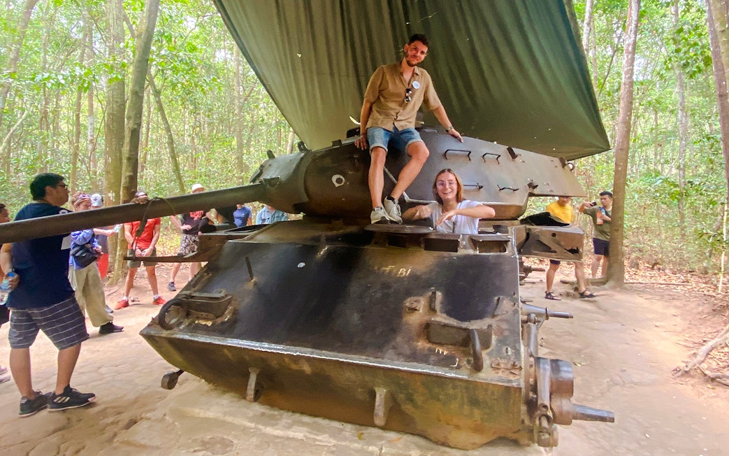 Tour group exploring a tank at Cu Chi tunnels, Vietnam.