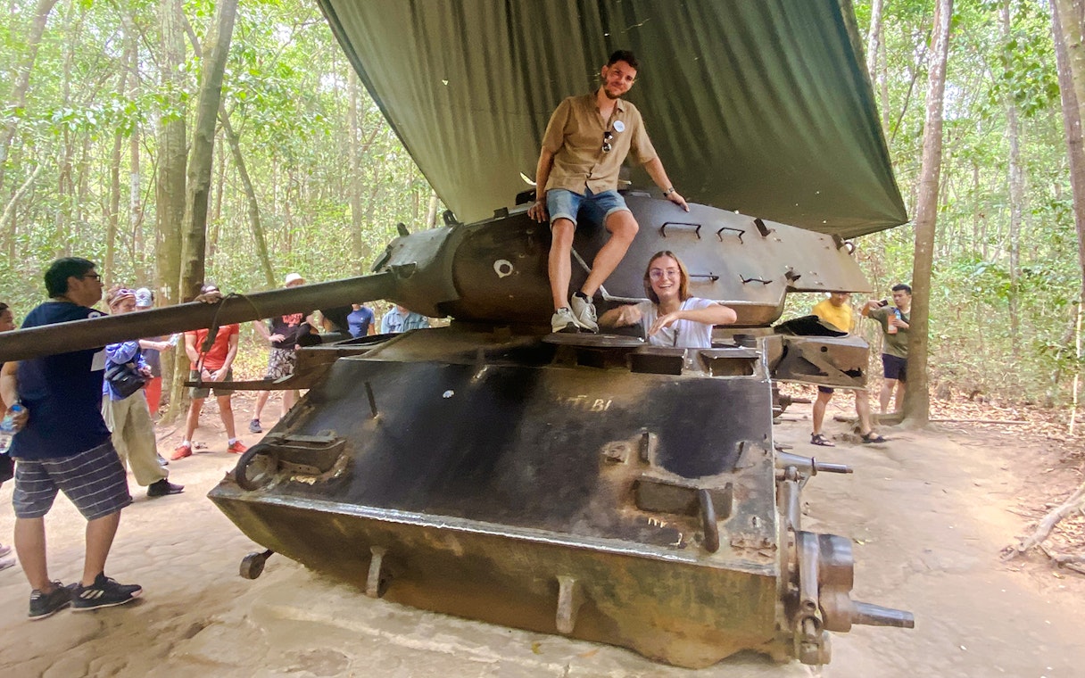 Tour group exploring a tank at Cu Chi tunnels, Vietnam.