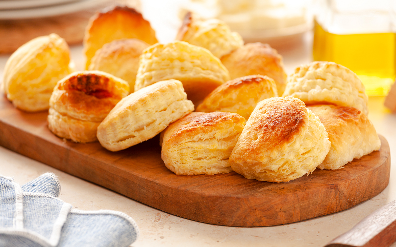 Greek pies on a wooden board with olive oil in the background.