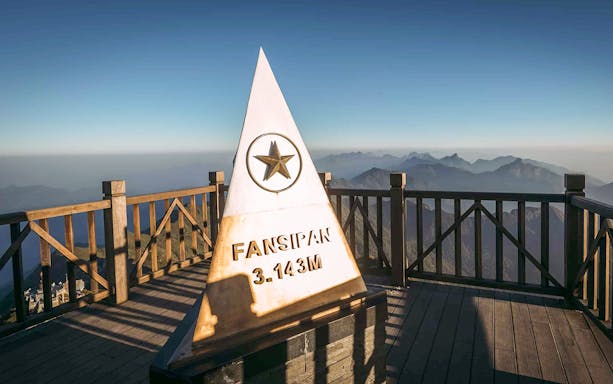 Fansipan summit marker at Sun World Fansipan, Vietnam, with mountain view.
