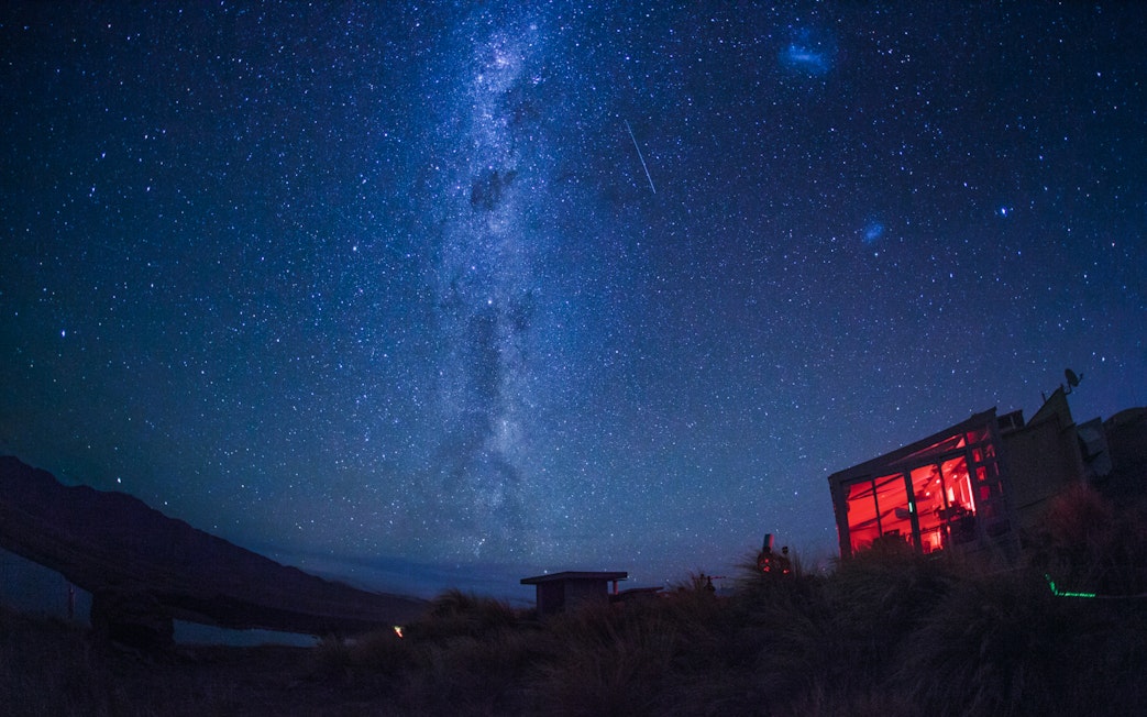 Stargazing at Mt. John Observatory under a starry sky with visible Milky Way.