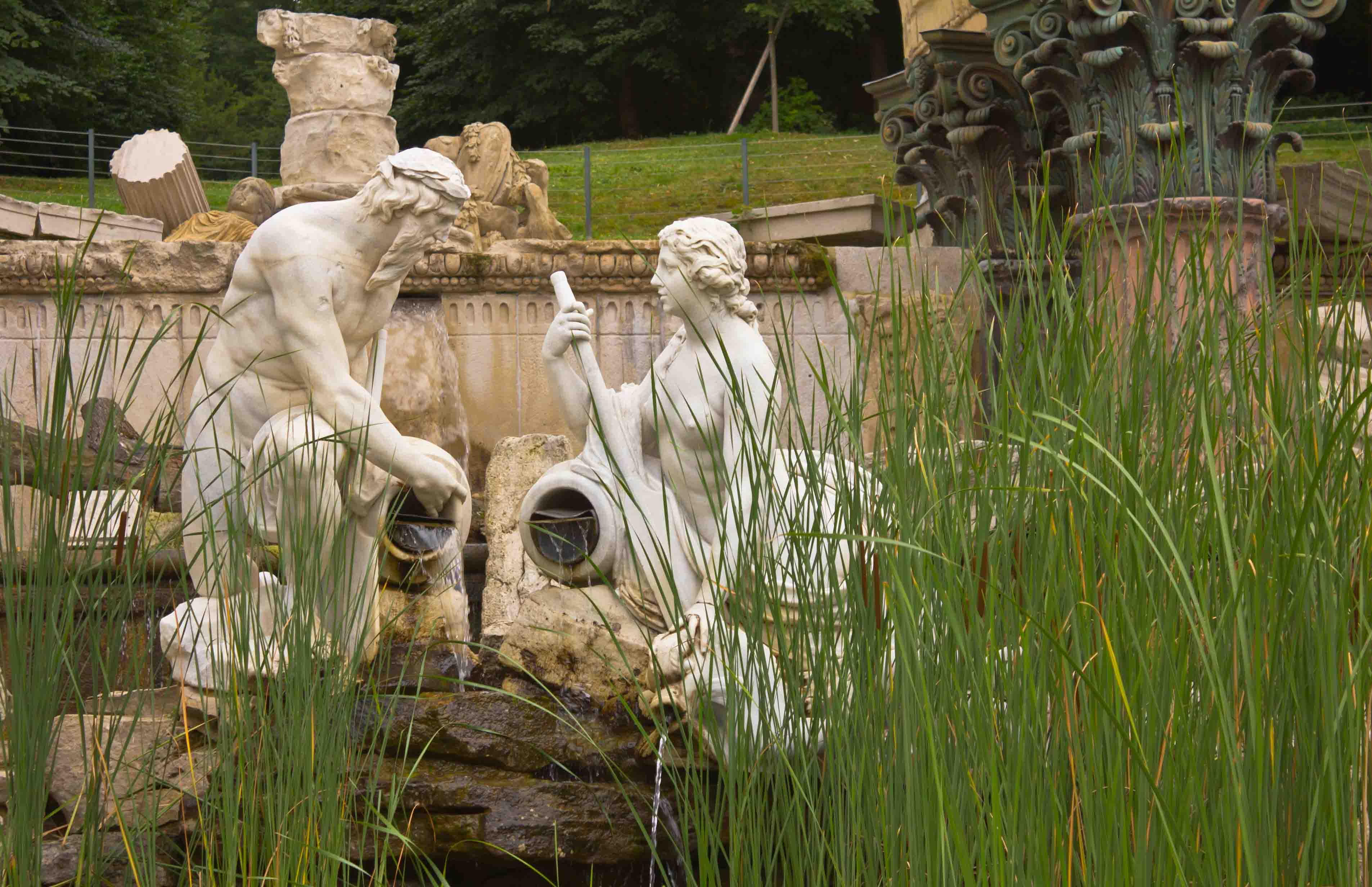 Schönbrunn Palace Garden ruins with classical statues and lush greenery in Vienna, Austria.