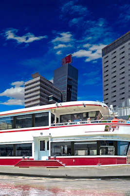 Boat on the Danube River with cityscape backdrop, part of Blue Danube Waltz tour.