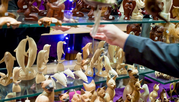 Wooden animal figurines displayed at a zoo aquarium gift shop.