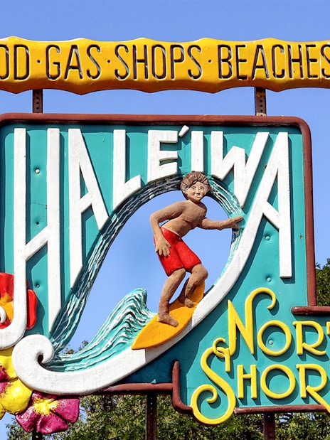 Haleiwa Town sign with surfer and North Shore text, Oahu, Hawaii.