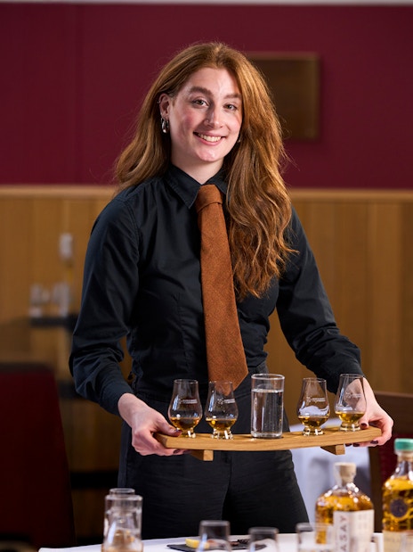 Host presenting whisky samples at the Scotch Whisky Experience.