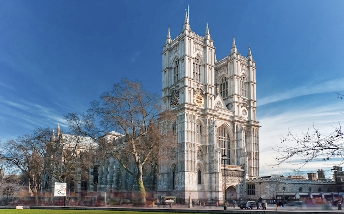 Westminster Abbey with afternoon tea bus passing in London.