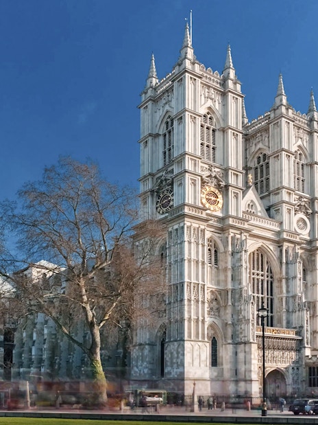 Westminster Abbey with afternoon tea bus passing in London.