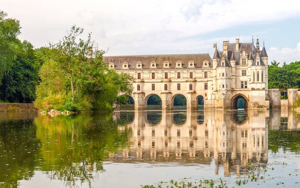 Chenonceau Castle reflecting on Cher River, Loire Valley, France.