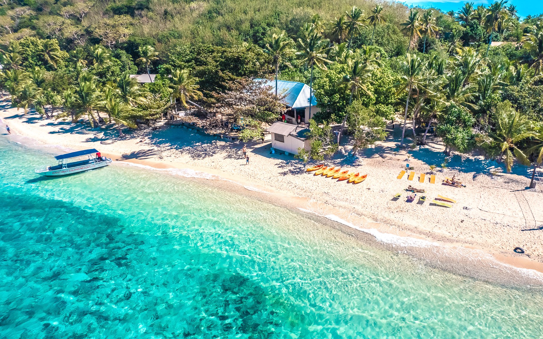 Mantaray Island Resort beach with kayaks and boat in Fiji.