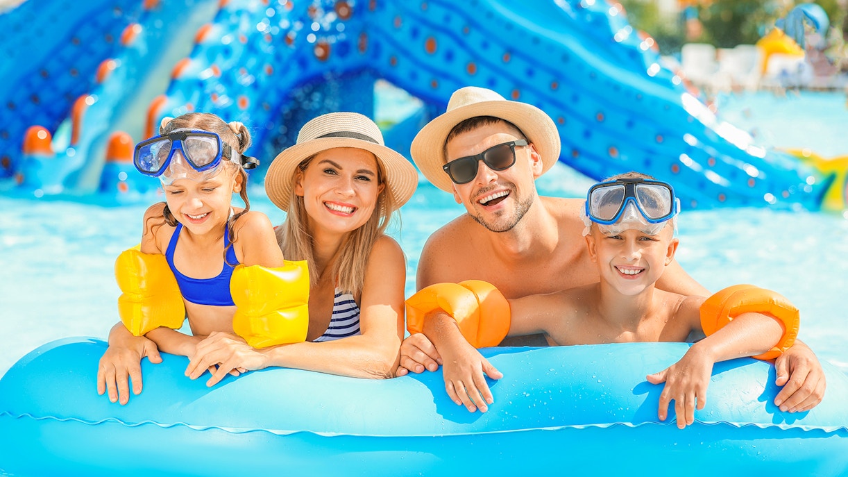 Family enjoying a day at Wet World Water Park in a pool with inflatable toys.