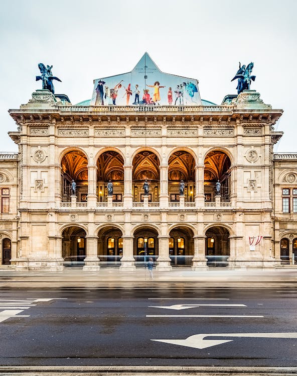 Vienna State Opera facade with arches and statues, Austria.