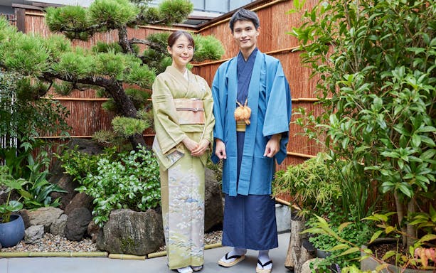 Couple in colorful kimonos at Tokyo Maikoya Tea Ceremony garden, Japan.