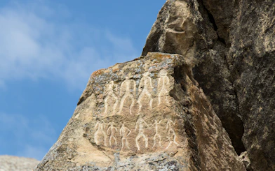 Petroglyphs of people on rock surface in Gobustan National Park, Azerbaijan.