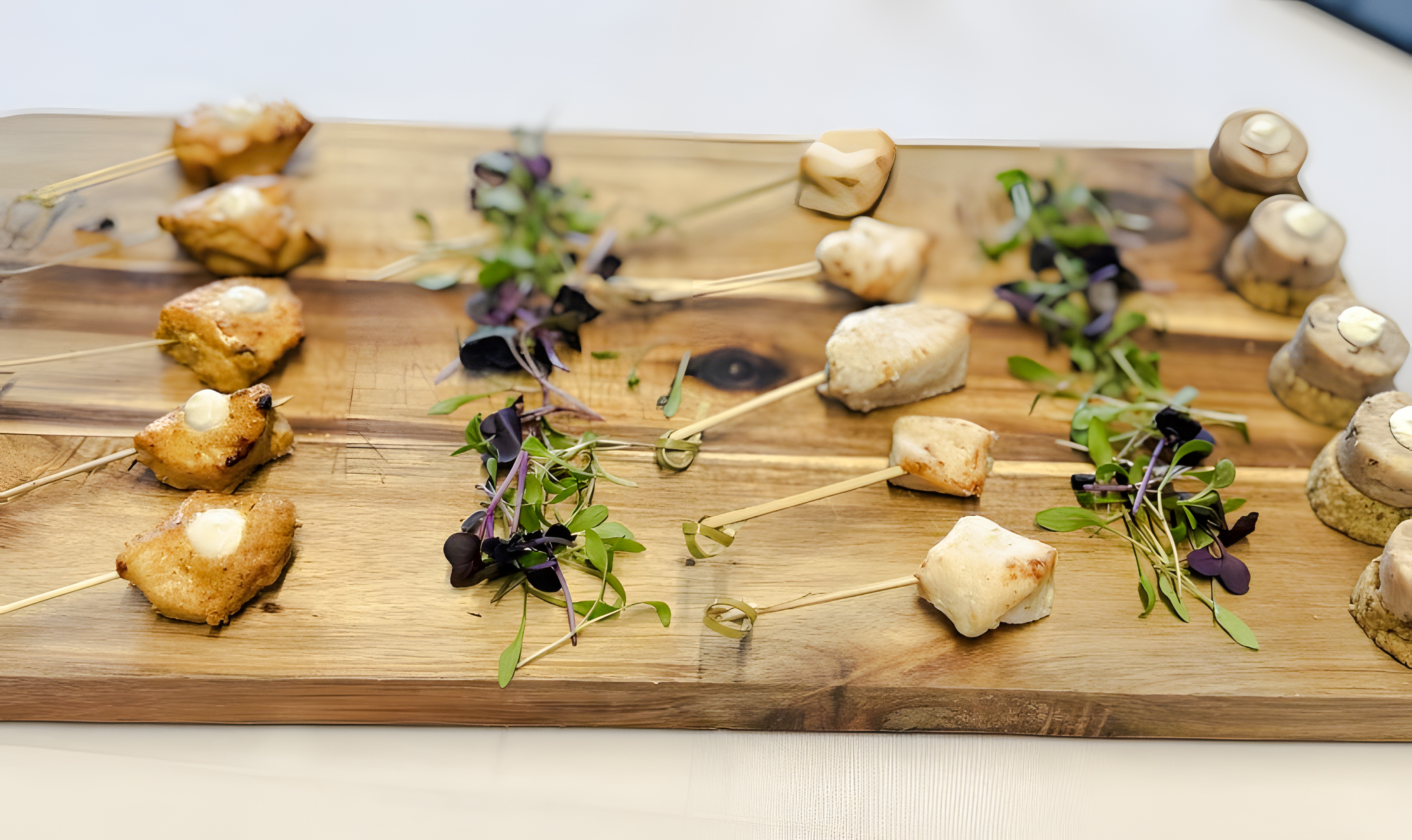 Professional catering platter with skewered appetizers and microgreens.