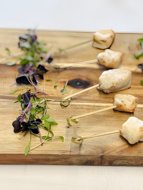 Professional catering platter with skewered appetizers and microgreens.