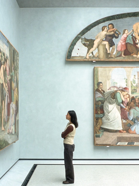 Visitor admiring Renaissance paintings in a Berlin museum gallery.