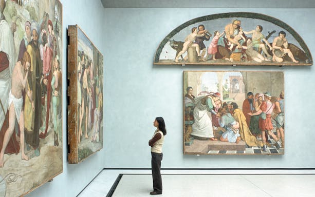 Visitor admiring Renaissance paintings in a Berlin museum gallery.