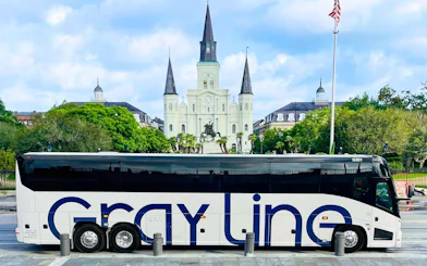 Tour bus in front of St. Louis Cathedral, New Orleans, for city and cemetery sightseeing tour.