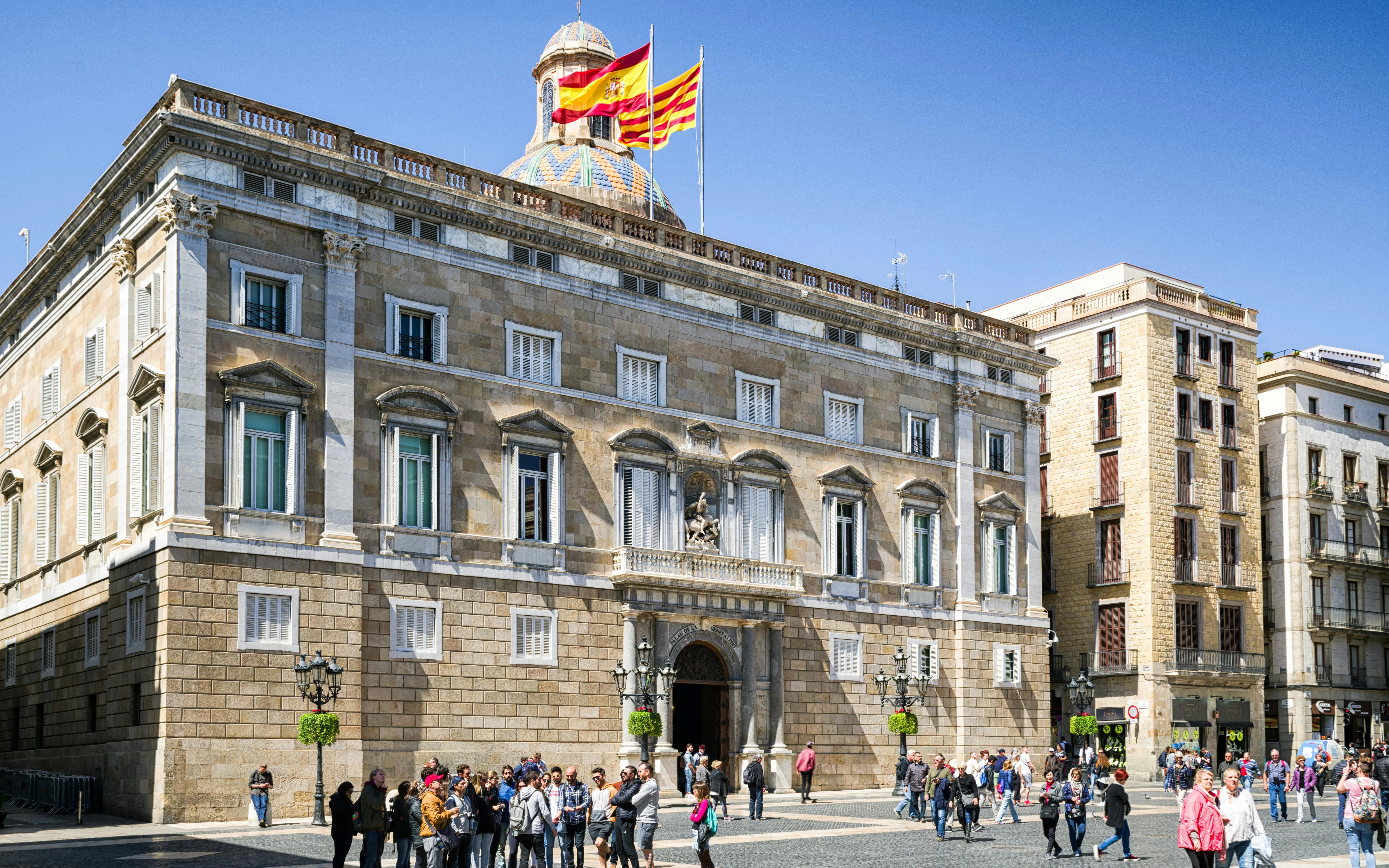Palau de la Generalitat de Catalunya in Barcelona with people walking in front.