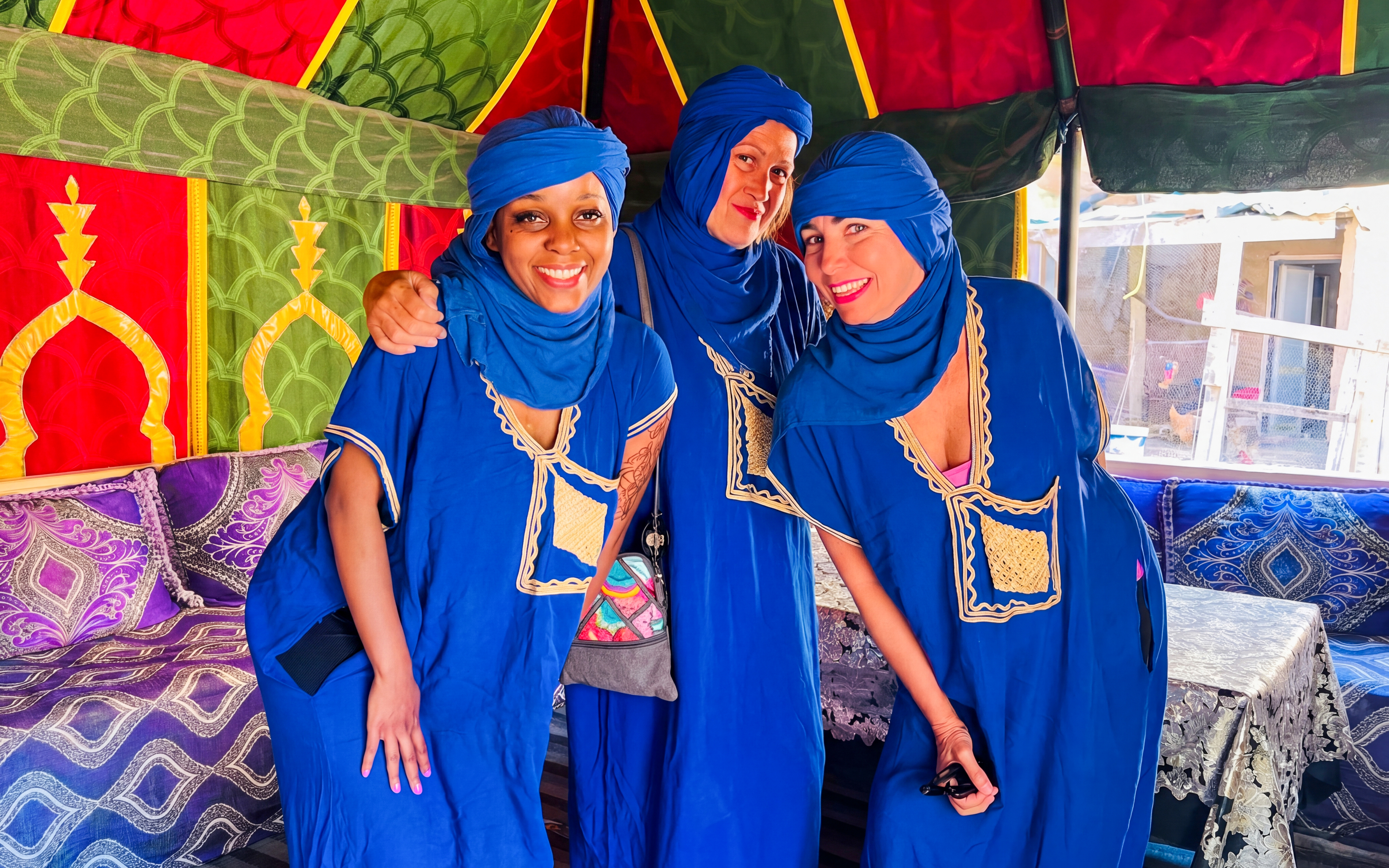 Visitors in traditional Moroccan attire inside a colorful tent during Palmeraie camel ride tour.