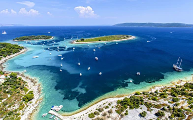 Boats anchored near islands in Blue Lagoon, Croatia, part of the Small Group 3 Islands tour.