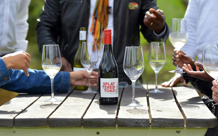 Tourists tasting wine at a table in Constantia, South Africa.