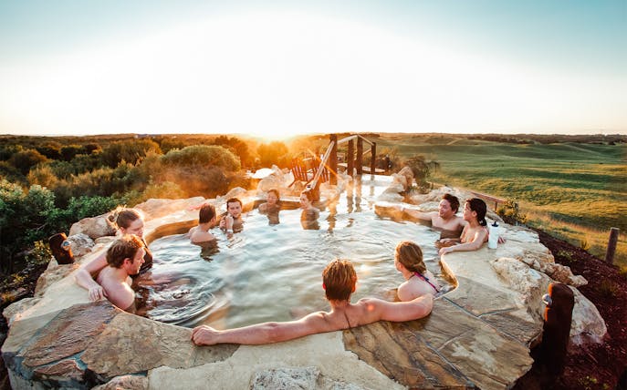 People relaxing in a hot spring at sunrise on the Mornington Peninsula, Melbourne.