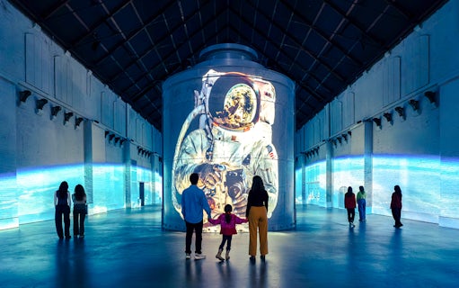 Guests viewing astronaut projection at Moonwalkers Exhibition, Fabrique des Lumières, Amsterdam.