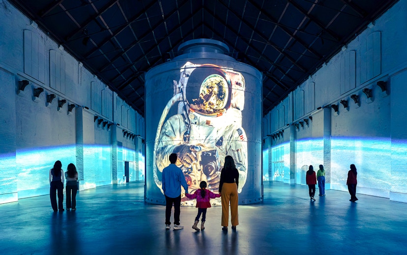 Guests viewing astronaut projection at Moonwalkers Exhibition, Fabrique des Lumières, Amsterdam.