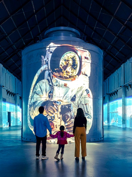Guests viewing astronaut projection at Moonwalkers Exhibition, Fabrique des Lumières, Amsterdam.