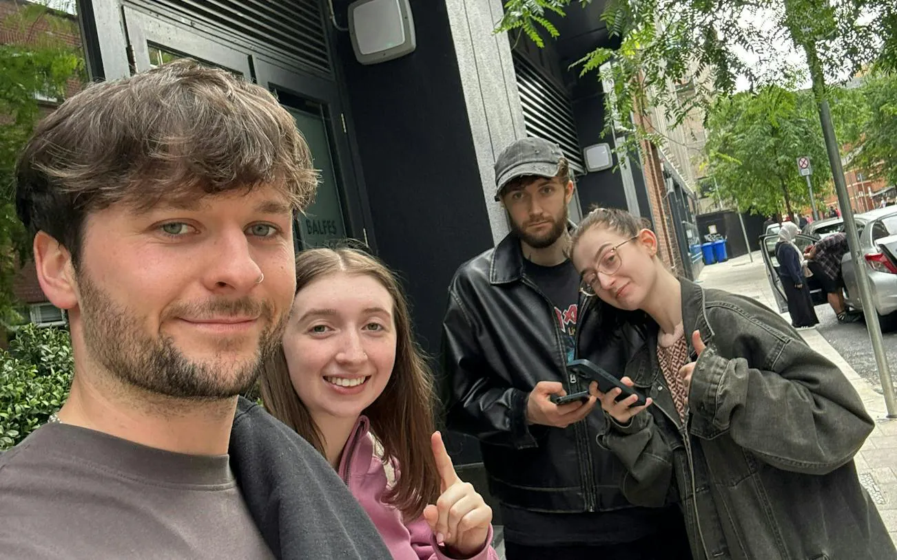 Group of friends participating in Dublin Secret Society Mystery game on city street.