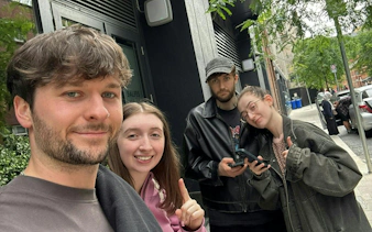 Group of friends participating in Dublin Secret Society Mystery game on city street.