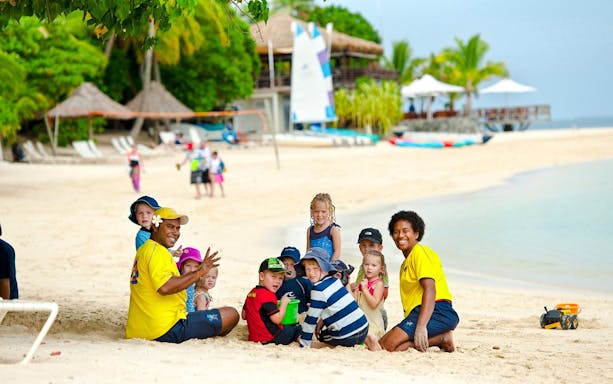 Family enjoying beach activities on Castaway Island, Fiji.