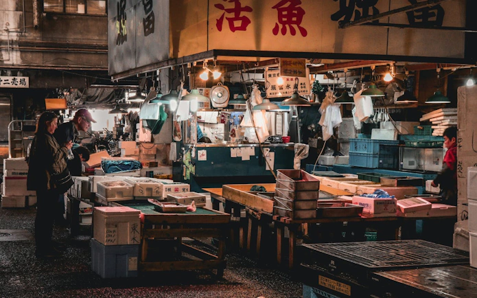 Visitors exploring Tsukiji fish market stalls in Tokyo.