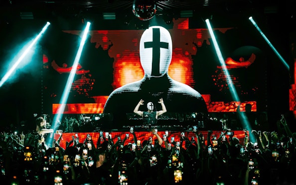 DJ performing at EPIC club after party in Prague with vibrant light show.