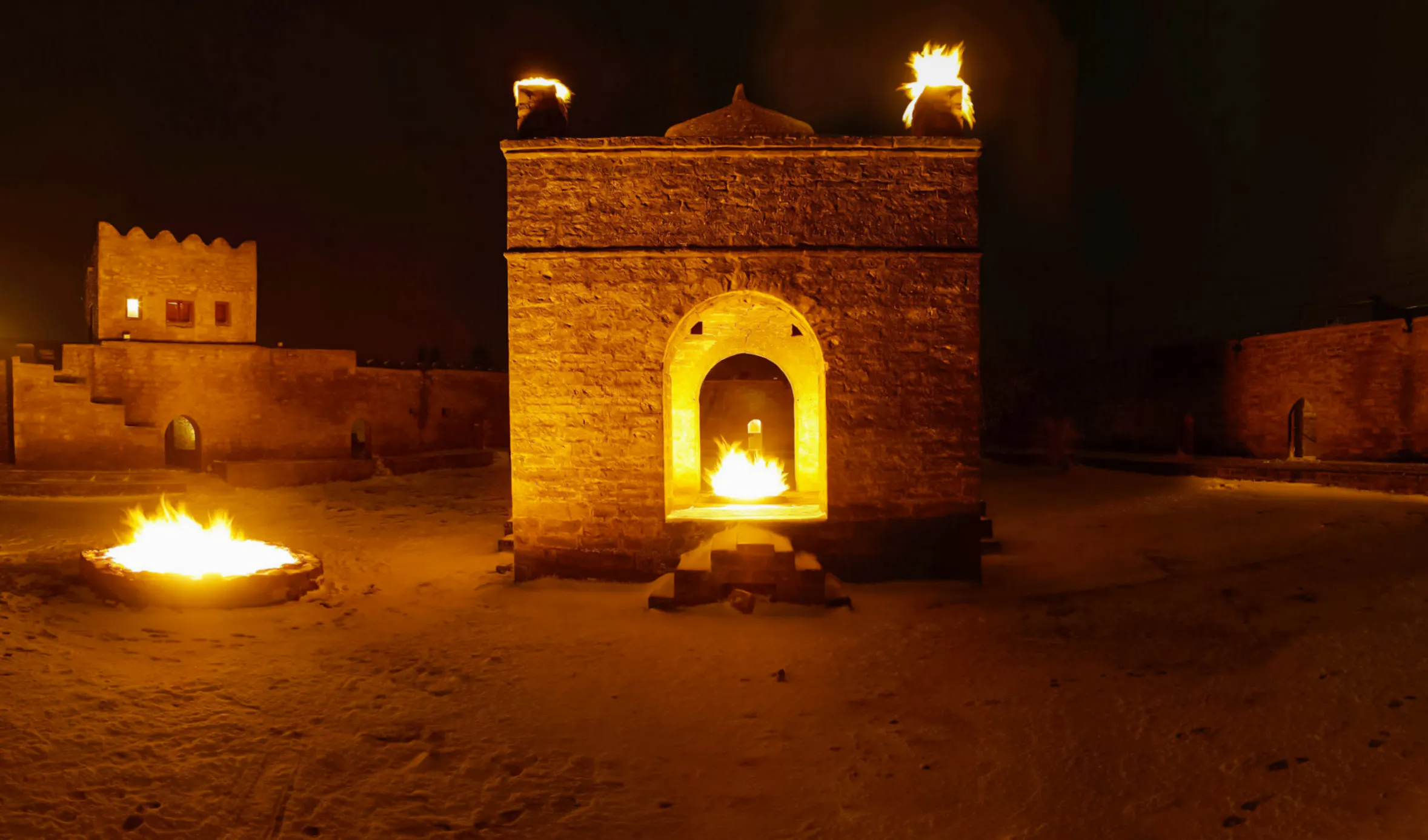 Azerbaijan's Ateshgah Fire Temple at night with flames, part of Baku: Gobustan - Absheron Tour.