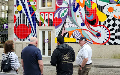 Tour group in Porto observing colorful tiled mural on walking tour.