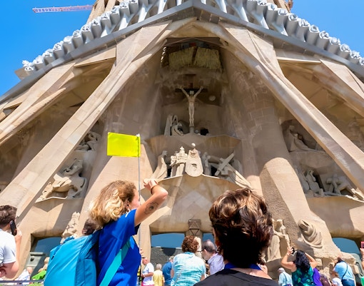 Tourist with guide outside Sagrada Familia, Barcelona, discussing architectural details.