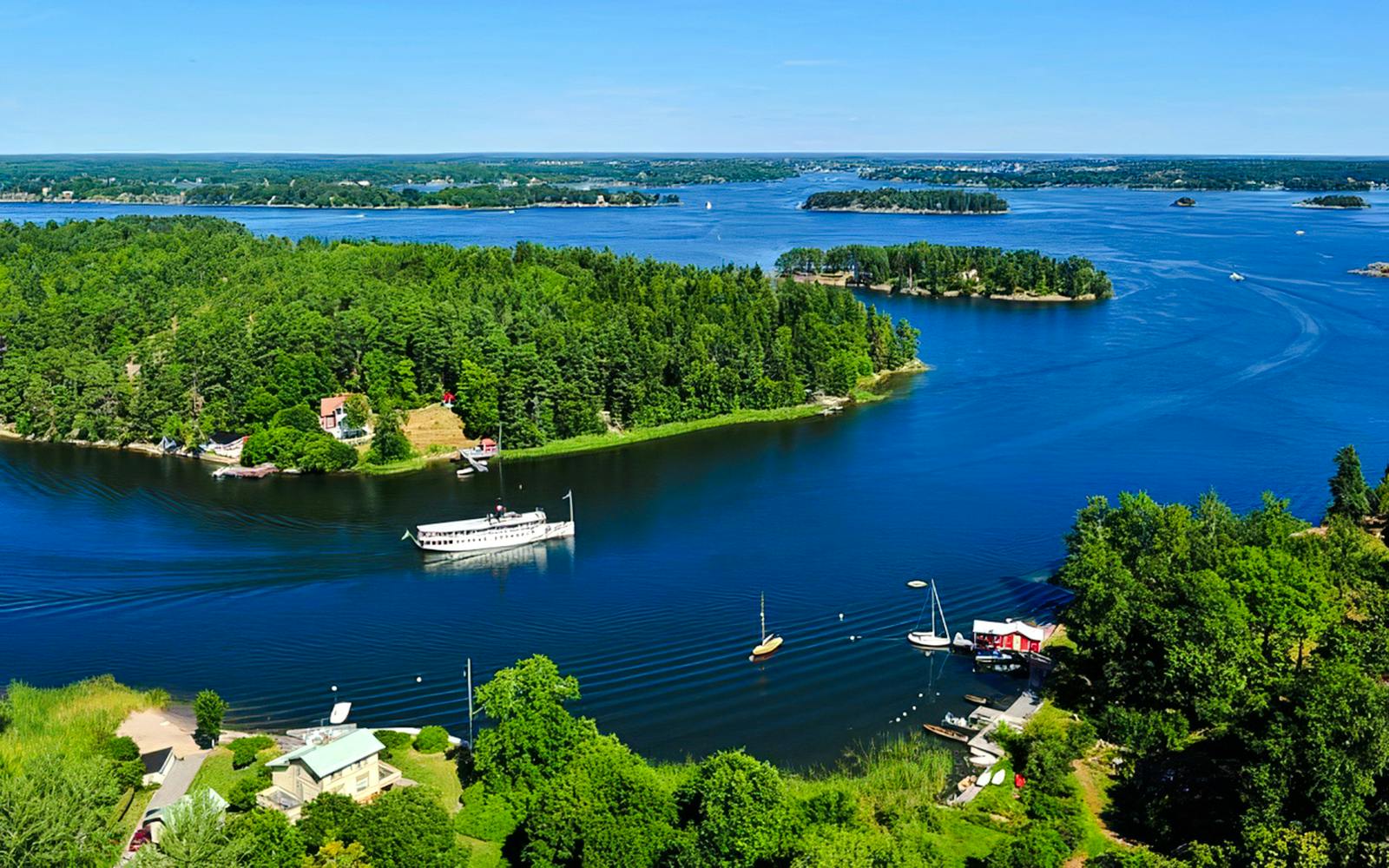 Aerial view of the Stockholm Archipelago with boats and lush green islands.