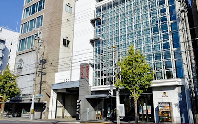 Exterior view of the AMTA building with glass facade in Kyoto, Japan.