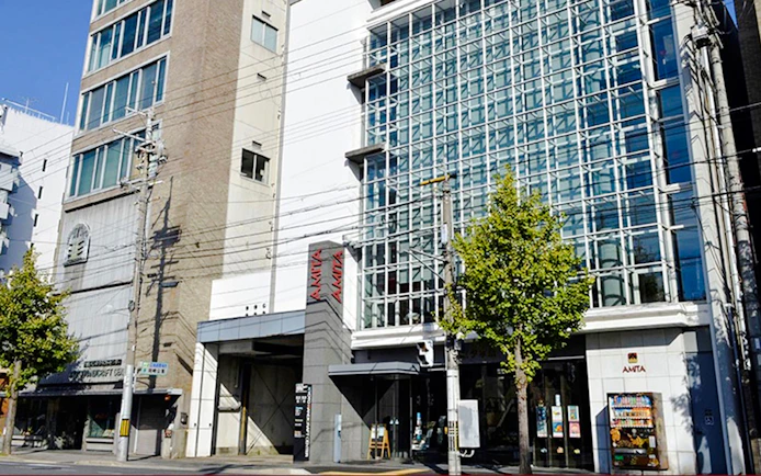 Exterior view of the AMTA building with glass facade in Kyoto, Japan.