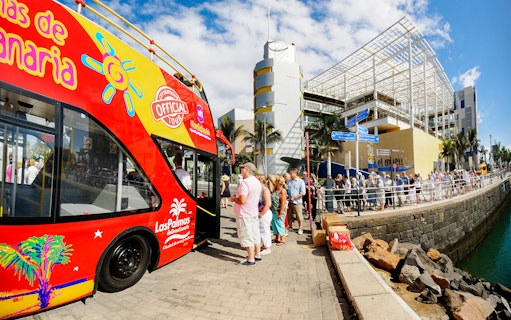 Hop-On Hop-Off bus at Las Palmas port with tourists boarding.