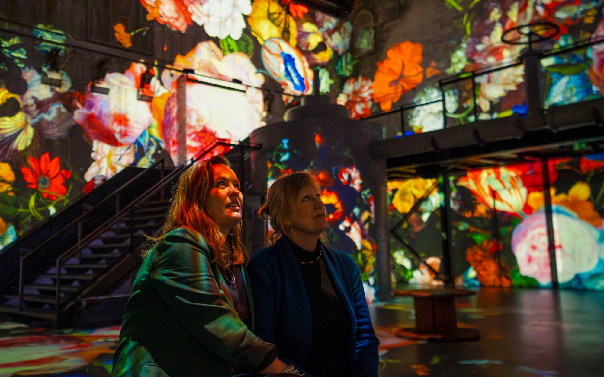 Visitors admiring floral projections at Dutch Masters Exhibition, Fabrique des Lumières.