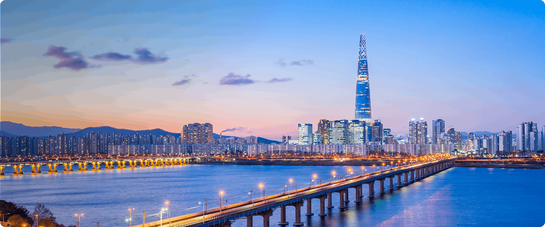 Seoul skyline with Lotte World Tower and Han River at dusk.