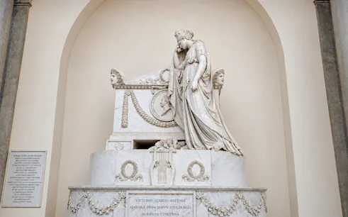 Tomb sculpture in Santa Croce, Florence, depicting a mourning figure and intricate carvings.