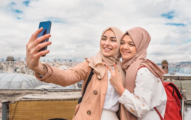 Women taking a selfie with Istanbul skyline in the background, using 4G Prepaid E-Sim for Turkey.