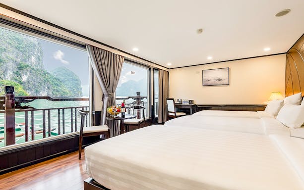 Ha Long Bay cruise ship sailing past limestone karsts and emerald waters in Vietnam.