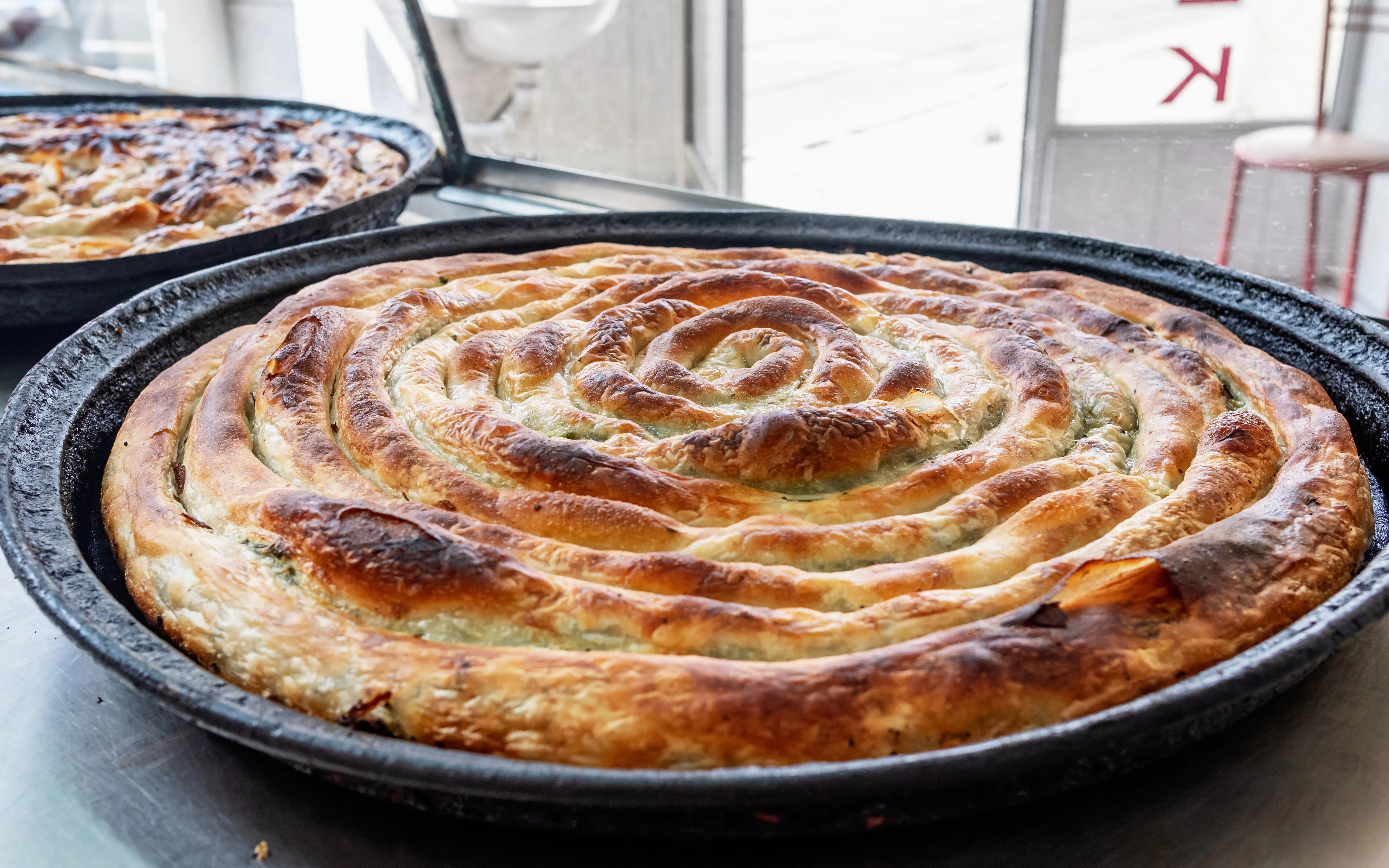Bosnian burek pastry in a round baking tray.